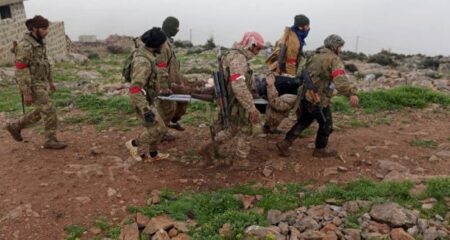 Syrian Army fighters carry a wounded colleague in Afrin, Syria.