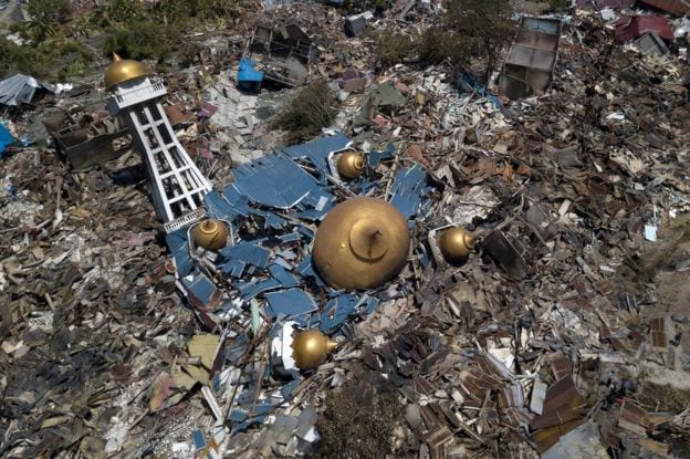 In Palu, rescuers are awaiting heavy machinery as this drone shot shows the destruction of a mosque.