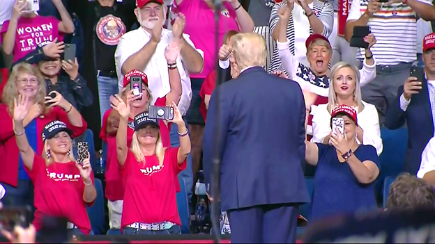 Trump greets supporters as he walks on stage at campaign rally. Most not wearing facemasks