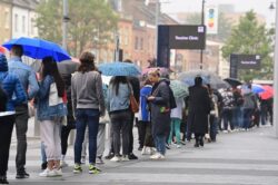 Thousands queue in the rain to get vaccinated as over-18s given jab