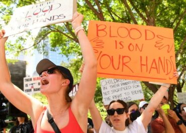 Protesters in support of gun control hold signs outside the annual meeting of the National Rifle Association at the George R. Brown Convention Center, on May 27, 2022, in Houston, Texas