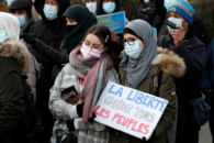 A woman holds a placard reading 'Freedom leads all the people' as protesters demonstrate against a bill dubbed as 'anti-separatism', in Paris, France