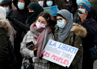 The Far-right in France claim victory - A woman holds a placard reading 'Freedom leads all the people' as protesters demonstrate against a bill dubbed as 'anti-separatism', in Paris, France