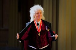 Sir Brian May on rock and rollicking good form as he receives knighthood from the King