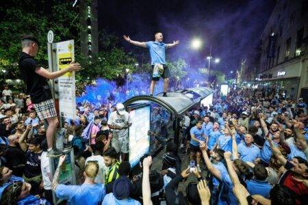 Man City fans jump on bus stops and smash cars in wild treble celebrations