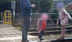 Dad caught on CCTV letting two young children play on live train tracks