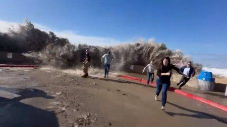 Terrifying moment rogue wave slams past seawall and hits fleeing beachgoers