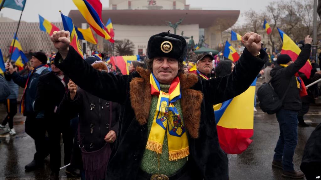 Romanians clench their fists as Romanian far-right supporters hold protest rally in Bucharest.