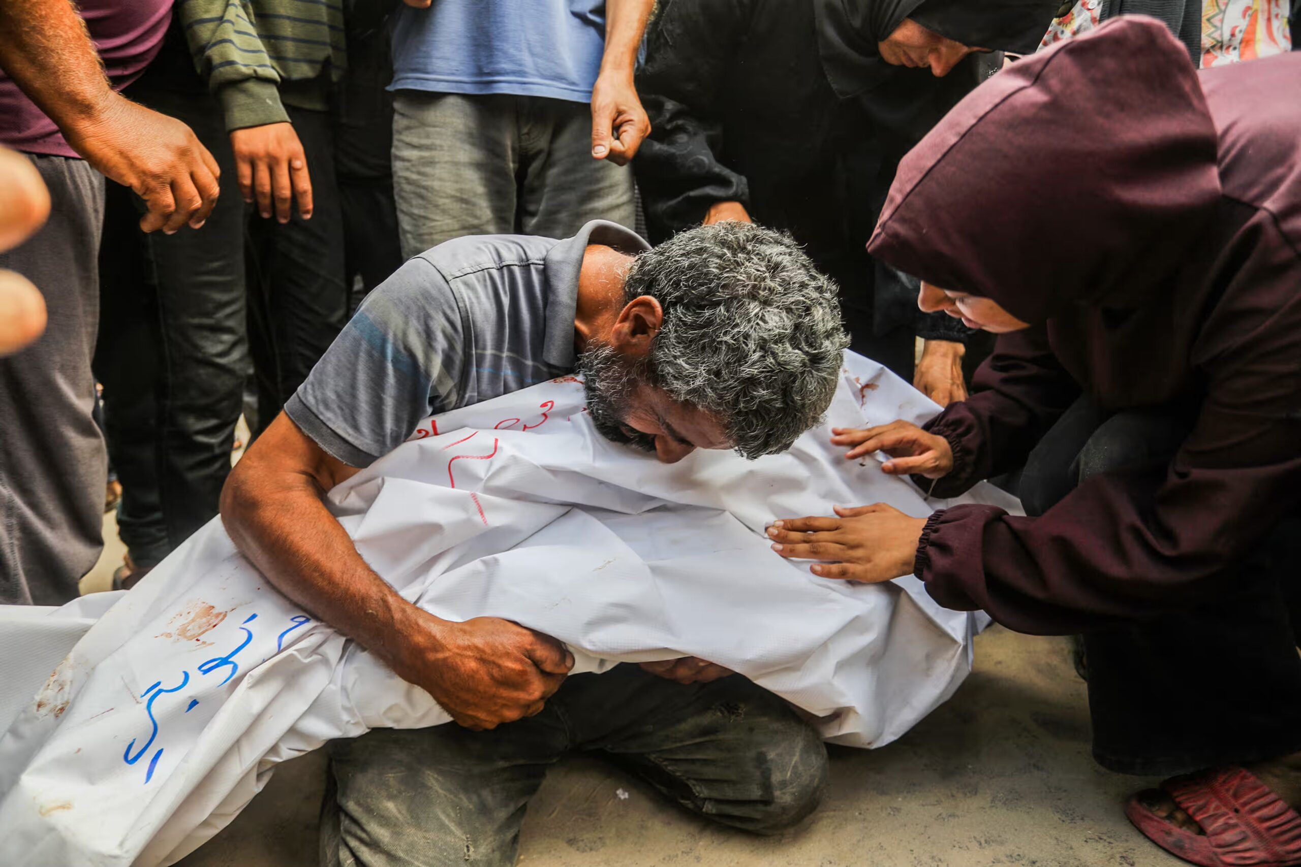 A man hugs the body of a dead loved one at Nasser hospital after an Israeli attack on the al-Mawasi area in Gaza