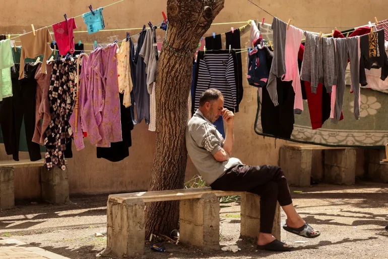 A displaced man, who fled his home after an Israeli evacuation order, sits in a university-turned-shelter in Sidon, 