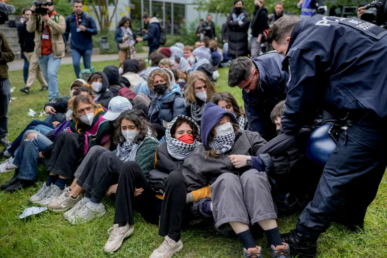 A man is carried away by police officers during a pro-Palestinians demonstration by the group "Student Coalition Berlin" in the theater courtyard of the 'Freie Universität Berlin' university in Berlin