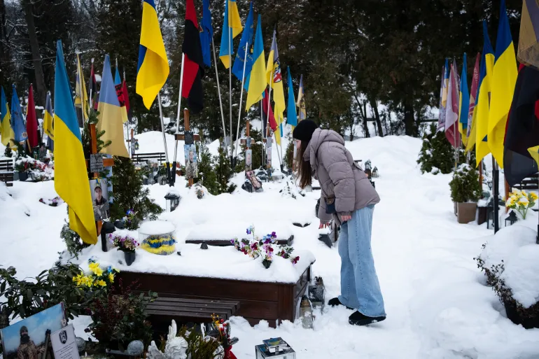 In Lviv, a woman visits the grave of her father, a Ukrainian soldier who died on the front line. More than 55,000 Ukrainian soldiers have been killed on the battlefield, according to President Zelenskyy