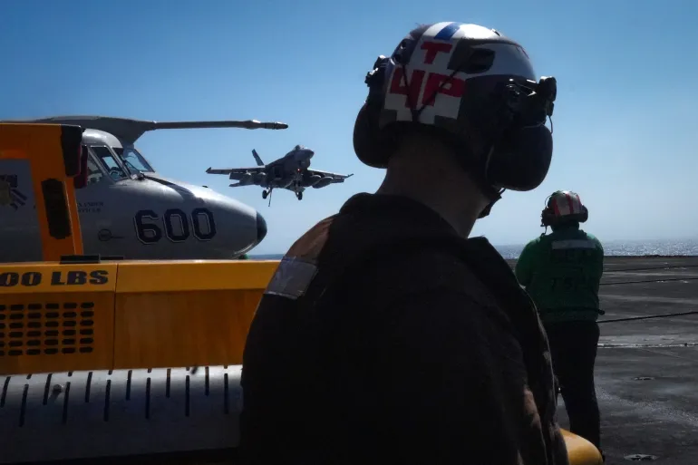 US Navy flight deck crew member watch as an F/A-18 Super Hornet lands aboard the aircraft carrier USS Theodore Roosevelt (CVN-71) while the ship is moored in Honolulu, Hawaii, during Exercise RIMPAC (Rim of the Pacific) 2026 on July 17, 2026. (Photo by Michelle Bir / AFP)